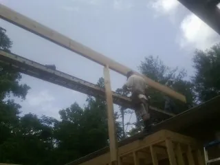 Carpenter setting a ridge beam over a new addition frame — Ice Dam Removal by Roofing Brothers in Detroit Lakes