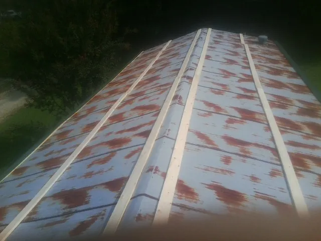 Rusted metal roof panels with new wood purlins before replacement — Storm Damage Roof Repair in Detroit Lakes by Roofing Brothers