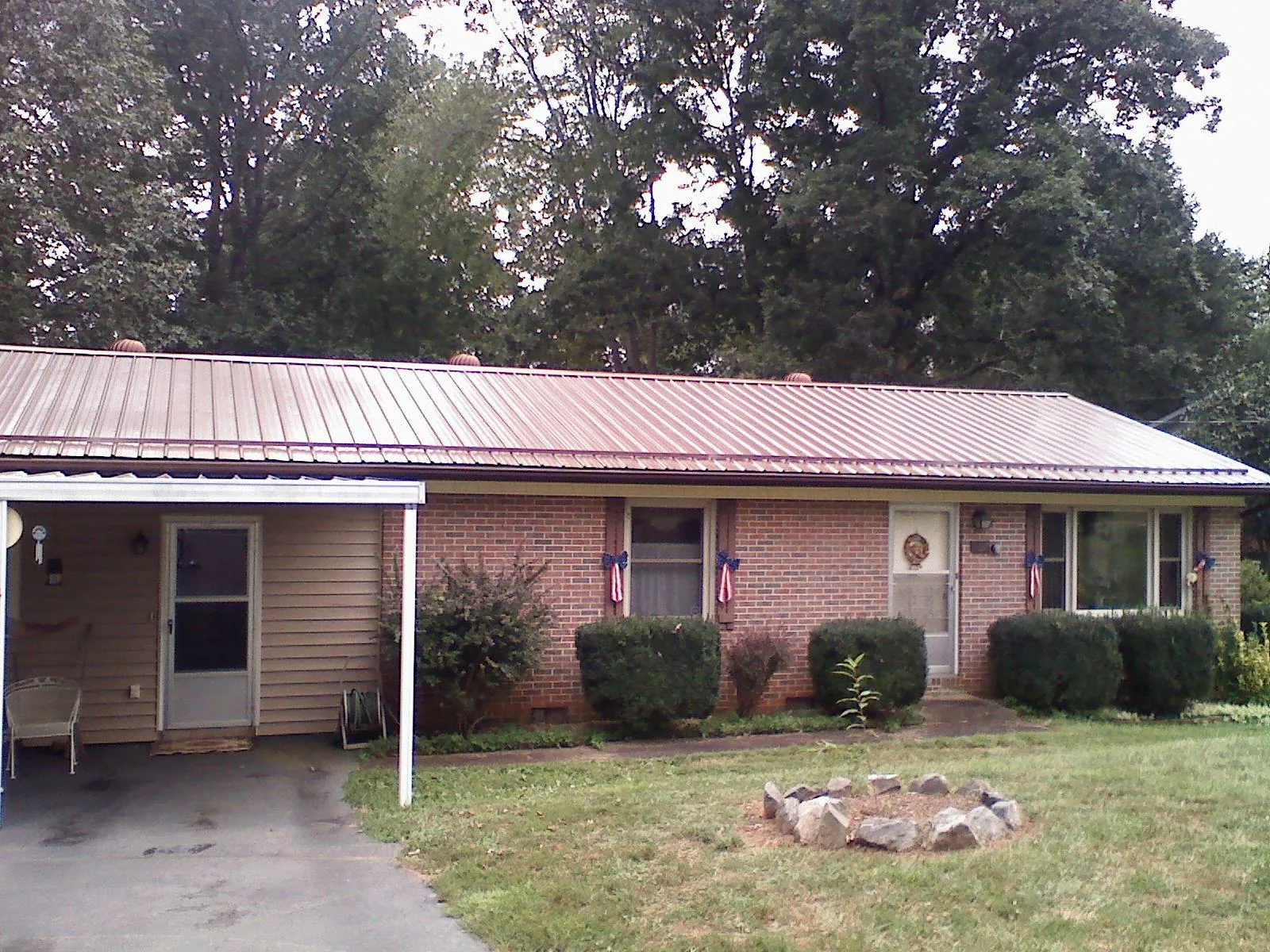 Bronze metal roof and carport on a brick ranch home — Roof Repair work by our crew in Detroit Lakes